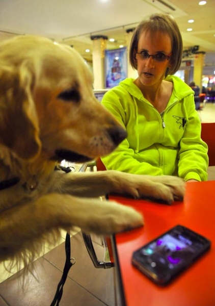A hallássérült Loványi Esztert kutyája, Kuku figyelmezteti a telefon csörgésére egy budapesti bevásárló központban